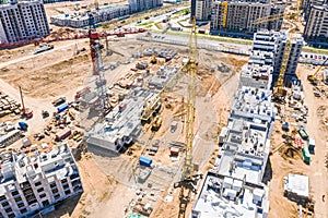 Aerial panoramic view of city construction site with tower cranes and other building machinery