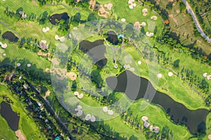 Aerial panoramic view drone shot of beautiful golf course with people playing golf in field