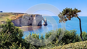 Aerial panoramic view of Etretat coastline, natural stone arch and the beach. Etretat, Normandy, France.