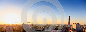 Aerial panoramic view of evening sunset cityscape, industrial area