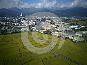 Aerial panoramic view of a factory with smoking chimneys by green rice paddies in Yilan Ilan photo