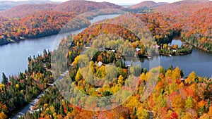 Aerial panoramic view of fall season foliage colors and secluded lake houses