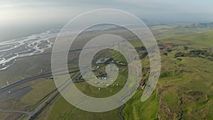 Aerial panoramic view of flat landscape with cliff and elevated plateau. Wide river, road and camping site near