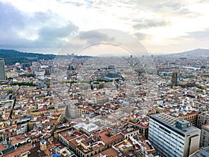 Aerial panoramic view of historic quarter of metropolis. Buildings and narrow aisles in large city at dusk. Barcelona