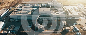 Aerial panoramic view of industrial factory or warehouse modern building in sunlight, drone point of view