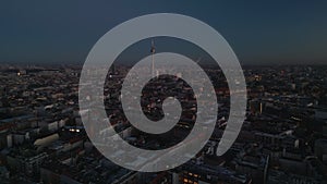 Aerial panoramic view of large city at dusk. Town development in urban neighborhood. Tall Fernsehturm in background