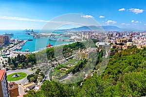 Aerial panoramic view of Malaga city, Andalusia, Spain in a beautiful summer day with many green park spots the port and