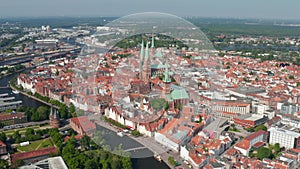 Aerial panoramic view of medieval city centre with tall churches towers. Historic town surrounded by river Trave