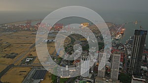 Aerial panoramic view of modern urban borough and container terminal in seaport at dusk. Colombo, Sri Lanka
