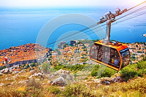 Aerial panoramic view of the old town of Dubrovnik with famous Cable Car on Srd mountain on a sunny day