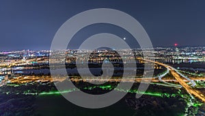 Aerial panoramic view over Vienna city with skyscrapers, historic buildings and a riverside promenade night timelapse in