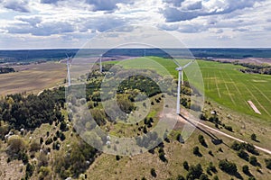 aerial panoramic view on rotating blades of windmill propeller on blue sky background. Wind power generation. Pure green energy