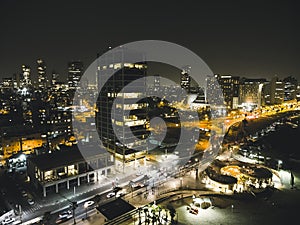 Aerial panoramic view of Tel Aviv city at night, nightlife in Tel Aviv metropolian area. Modern illuminated skysrapers and