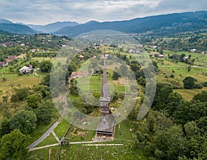 Aerial panoramic view of traditional ancient Maramures wooden orthodox church in Transylvania with highest wooden