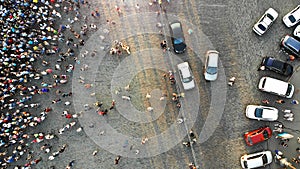 Aerial. Parking lot with cars and people crowd. Crowded city square. Top view