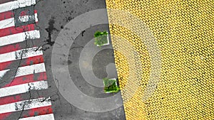 Aerial. Pedestrian crosswalk on asphalt road and yellow paving stone.