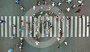 Aerial. Pedestrians passing a crosswalk. Rush hour in the city. People are rushing to work.