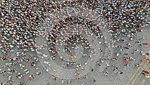 Aerial. People crowd on a city square. Mass gathering of many people in one place. Top view from drone