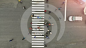 Aerial. People crowd on pedestrian crosswalk. Zebra crossing, top view
