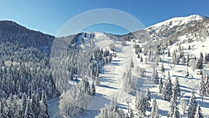 Aerial: People Skiing In Beautiful Snowy Soriska Planina Ski resort, Slovenia