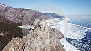 Aerial perspective view of beautiful deep blue ice textured frozen Baikal lake surface and coast from above captured