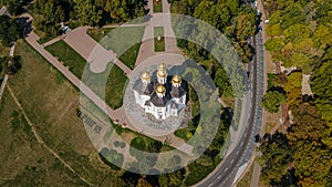 Aerial photo of ancient european Chernihiv town with church near road, trees and buildings