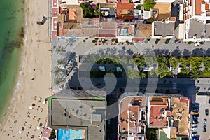 Aerial photo of the beautiful island of Ibiza in Spain showing a top down view of the street and beach with hotel complexes and