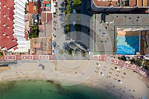 Aerial photo of the beautiful island of Ibiza in Spain showing a top down view of the street and beach with hotel complexes and