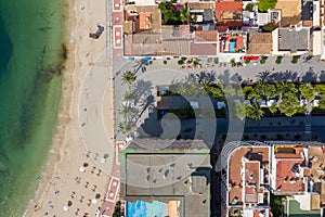 Aerial photo of the beautiful island of Ibiza in Spain showing a top down view of the street and beach with hotel complexes and
