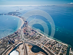 Aerial photo of buildings, villas and the beach on a natural spit of La Manga between the Mediterranean and the Mar Menor,
