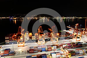 Aerial photo of cargo terminal loading shipping containers onto cargo ships, marine terminal, cargo crane, port of