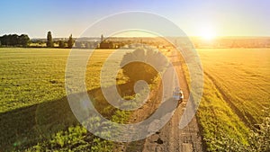 Aerial photo from drone. Automobile drives along the road at sunset.