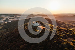 Aerial photo by drone of The Barrow cairn of Milan Rastislav Stefanik upon Hill with beautiful green trees around - on sunset.