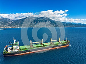 Aerial photo of huge bulk carrier tanker anchored in deep blue Aegean sea