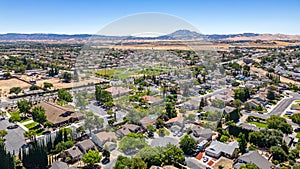 Aerial Photo over a neighborhood in Oakley, California with streets, trees, houses and a beautiful blue sky
