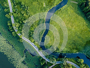 Aerial Photo of Road going by the River under the Trees, Top Down View in Early Spring on Sunny Day