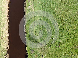 Aerial photo of a small river by meadows, abstract photo