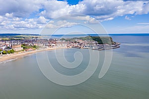 Aerial photo of the town centre of Scarborough in East Yorkshire in the UK showing the coastal beach and harbour with boats and