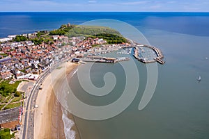 Aerial photo of the town centre of Scarborough in East Yorkshire in the UK showing the coastal beach and harbour with boats and