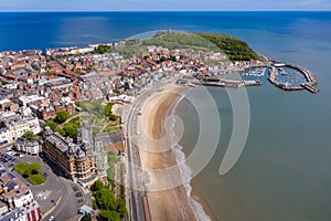 Aerial photo of the town centre of Scarborough in East Yorkshire in the UK showing the coastal beach and harbour with boats and