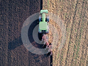 Aerial photo of a tractor ploughing a field in a countryside