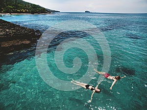 Aerial photo of young couple on holidays swimming in ocean
