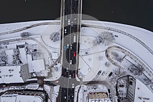 aerial photograph of a snowy road that curves across a river