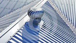 Aerial photograph of Whirlybird air ventilator a grey corrugated iron roof in the sunshine