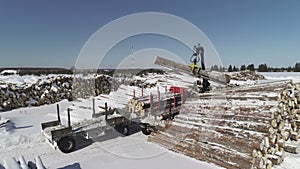 Aerial photography of unloading logs from a car trailer using a manipulator