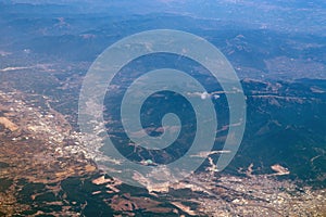 Aerial photography. View from the plane window: mountains and green fields. Travel and tourism concept.