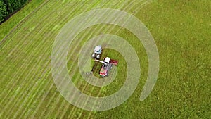 Aerial photography. Wide and close-up shots of a harvester cutting green grass. Birds of prey swirl over cars. The concept of sust