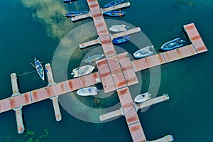 Aerial picture of floating dock with boats, motorboats and vessels floating on water in lake Small Prespes