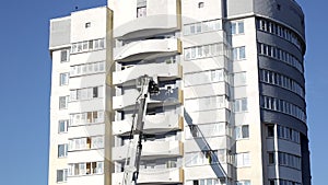 Aerial platform fire truck raises firefighters in a protective basket to extinguish a fire in a multi-story high-rise