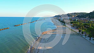 Aerial push-in shot from Cupra Marittima with Adriatic Sea, breakwaters, beach, fisherman, park, promenade